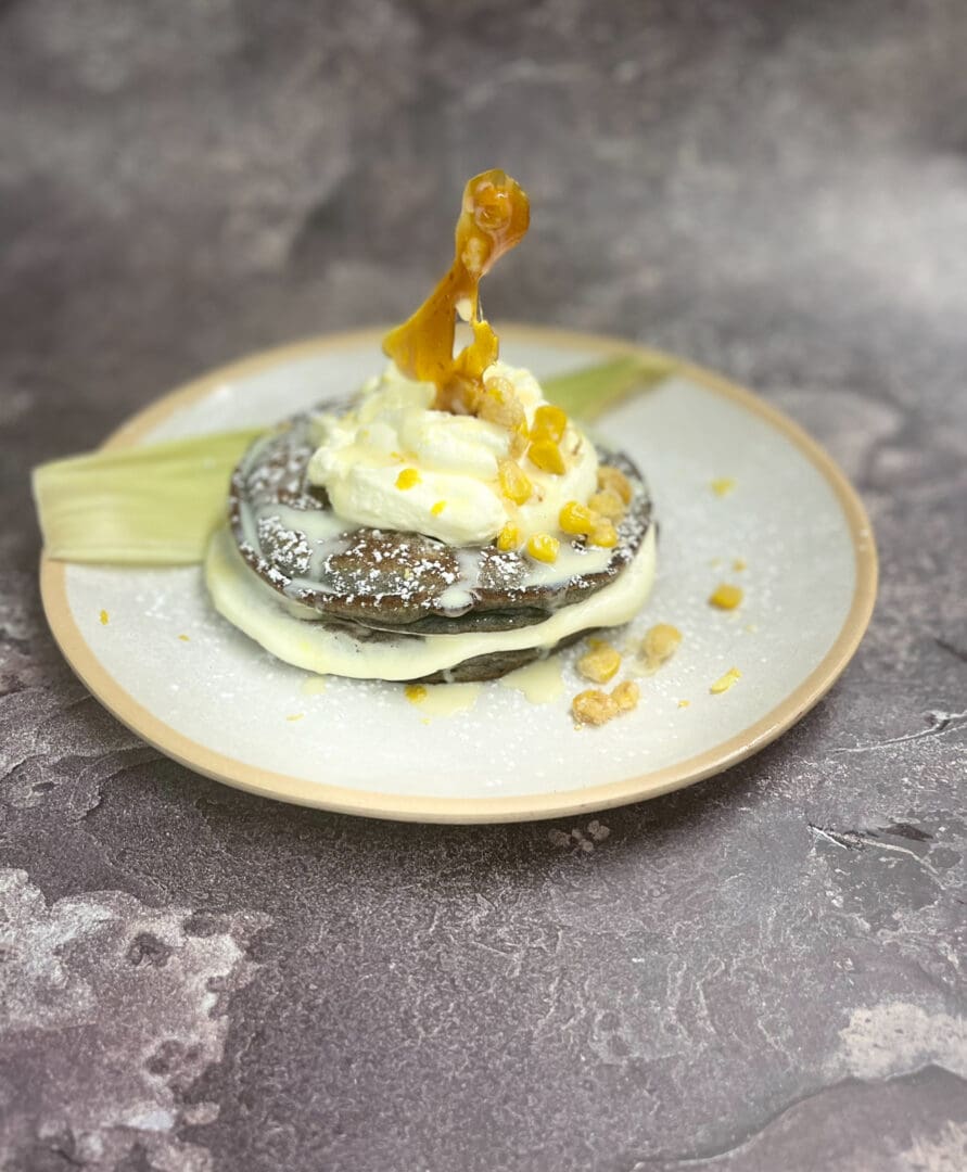 Cornmeal pancakes with whipped cream and caramel.