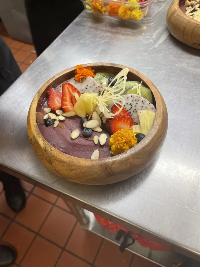 Wooden bowl with acai, fruit, and nuts.